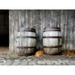 Image of photography artwork titled "Forty Winks" by Jessica St. Clair featuring a sleepy puppy nestled between two rustic wooden barrels in a barn setting.