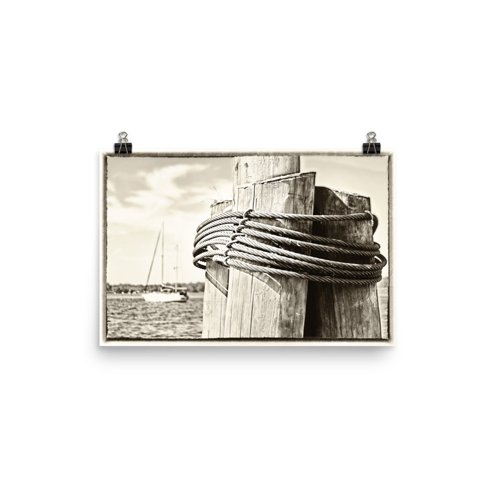 Image of Dockside mixed media sepia tone artwork on 12 inch by 18 inch enhanced matte photo paper by Jessica St. Clair depicting wood pilings and a sailboat at sea