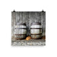 Image of Forty Winks photographic art print on 14 inch by 14 inch enhanced matte photo paper by Jessica St. Clair featuring a sleepy puppy nestled between two rustic wooden barrels in a barn setting.