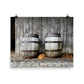 Image of Forty Winks photographic art print on 16 inch by 20 inch enhanced matte photo paper by Jessica St. Clair featuring a sleepy puppy nestled between two rustic wooden barrels in a barn setting.