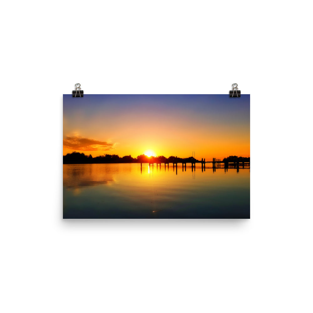 Image of Morning Majesty photographic art print on 12 inch by 18 inch premium luster photo paper by Jessica St. Clair depicting a colorful sunrise over a silhouetted dock stretching across the water