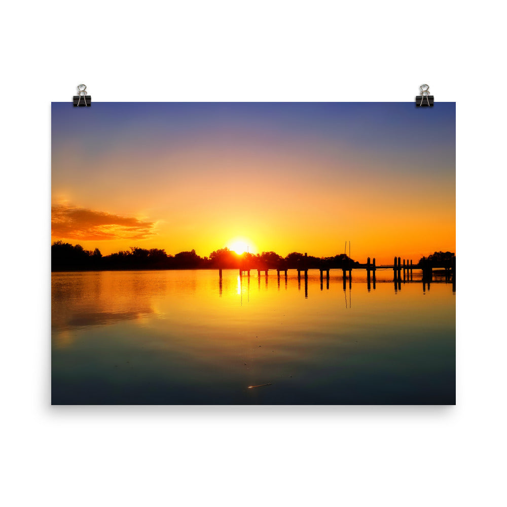 Image of Morning Majesty photographic art print on 18 inch by 24 inch premium luster photo paper by Jessica St. Clair depicting a colorful sunrise over a silhouetted dock stretching across the water