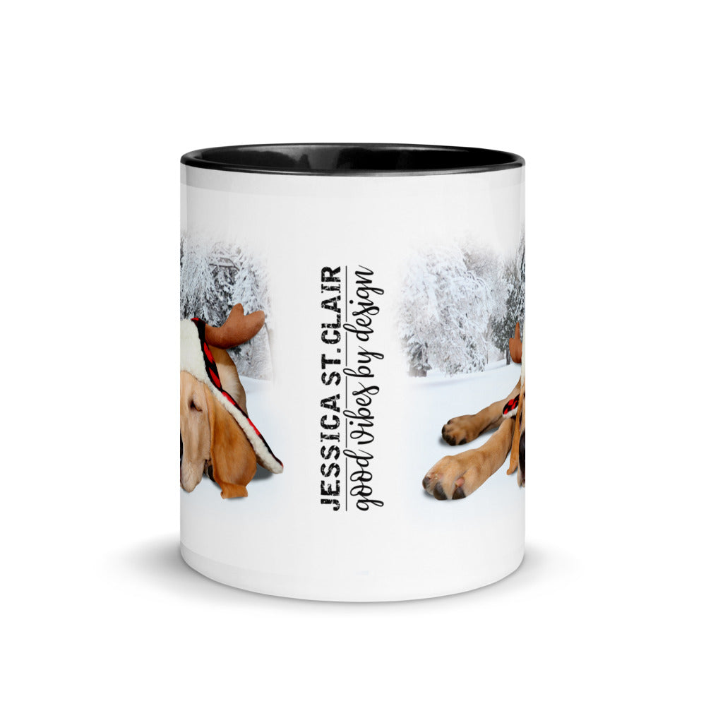 Image of center view of white ceramic mug featuring black inside and handle with photo of yellow lab puppy wearing lumberjack hat snoozing in the snow
