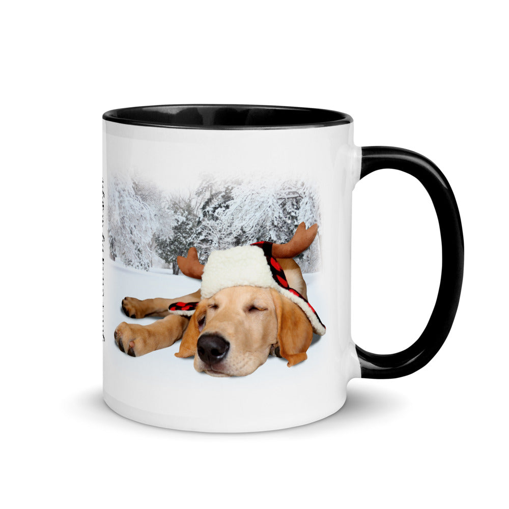 Image of front view of white ceramic mug featuring black inside and handle with photo of yellow lab puppy wearing lumberjack hat snoozing in the snow