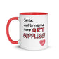 Image of back view of white ceramic mug featuring red inside and handle with Santa just bring me more art supplies saying